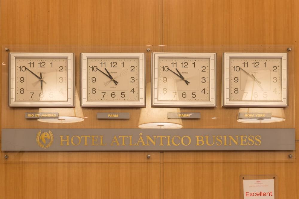 Hotel Atlântico Business Centro Rio de Janeiro Exterior foto The photo displays a wooden wall featuring three wall clocks. Each clock shows a different time, indicating that they are set to various time zones. Below the clocks, there is a sign that reads "HOTEL ATLÂNTICO BUSINESS." There are also two lamp fixt